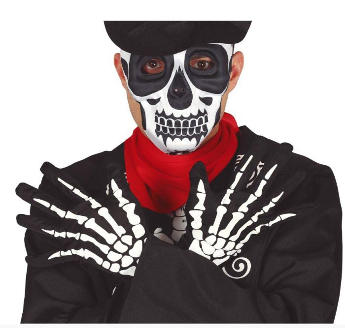 A person wearing a black Day of the Dead style costume jacket with white skeleton hand graphics, a bright red neck scarf, and a black hat, with skull face paint visible.