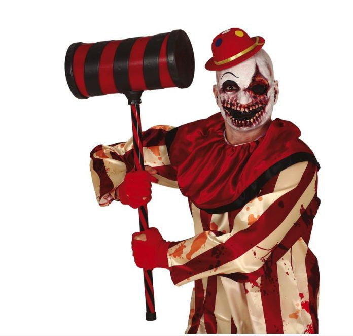 Person in a horror clown costume holding a large mallet on a white background
