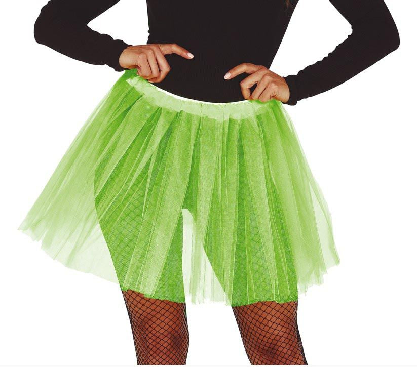 A model wearing a bright lime green tulle tutu skirt over black fishnet tights, holding the waistband of the skirt. The background is solid white.