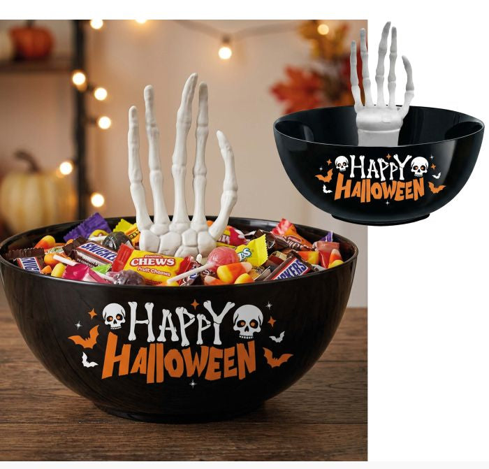 Black Halloween-themed candy bowl with 'Happy Halloween' text, skull and bat graphics, and two white skeleton hand props rising from the candy. A smaller inset shows the bowl alone with one hand inserted.