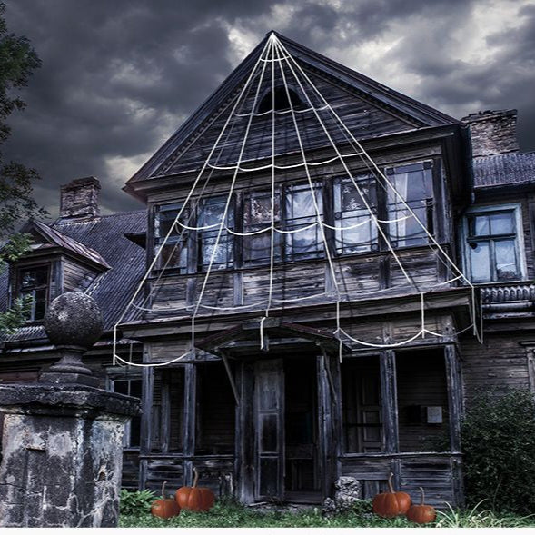 Old, eerie house with cobwebs and pumpkins on a dark day.