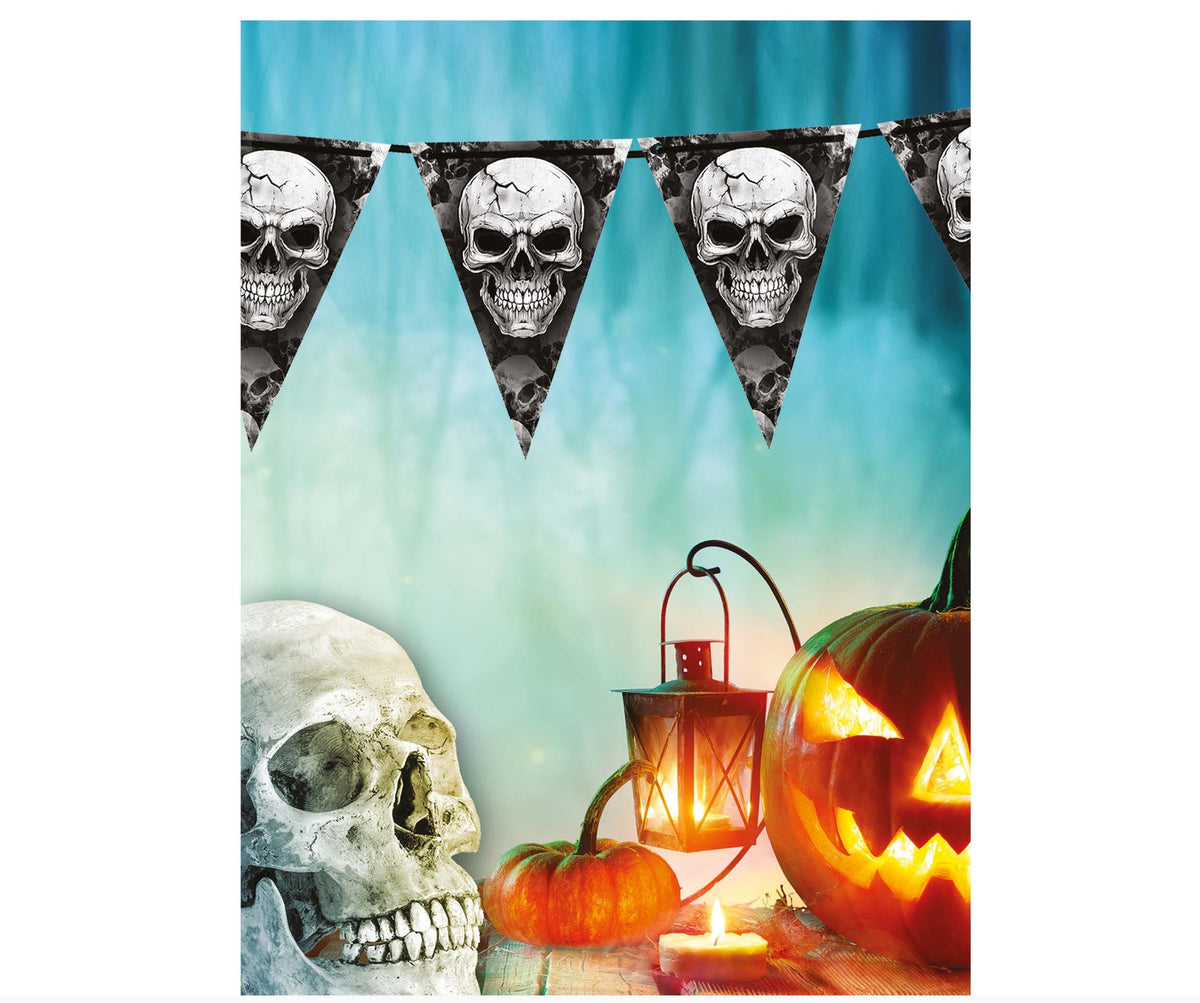 Halloween banner decoration featuring triangular pennants with skull designs, displayed above a styled scene with a large skull, a lit jack-o'-lantern, a lantern, and candles against a blue gradient background.