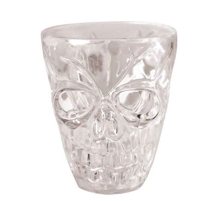 A clear glass skull-shaped shot glass with a textured, faceted design, shown on a white background with a copyright notice for Fiestas Guirca.