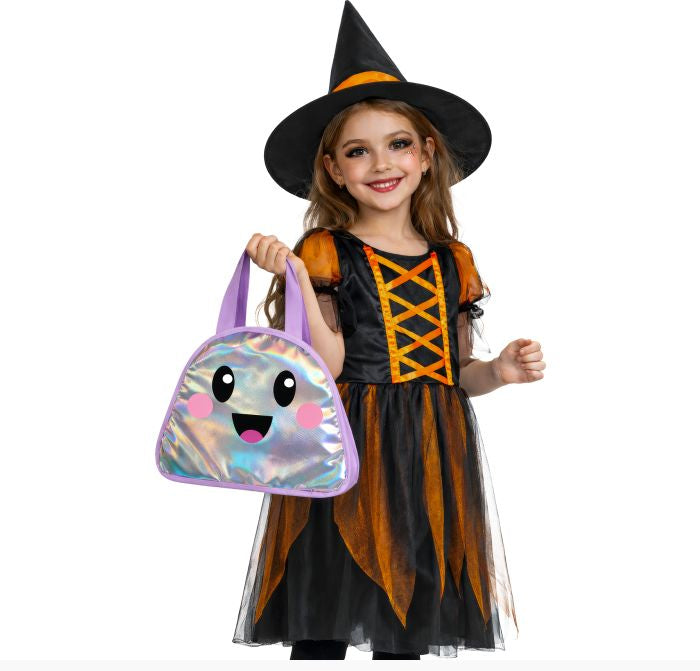 A young girl modeling a black and orange witch costume with a black pointed hat, holding a shiny holographic purple handbag with a cartoon face, against a plain white background.