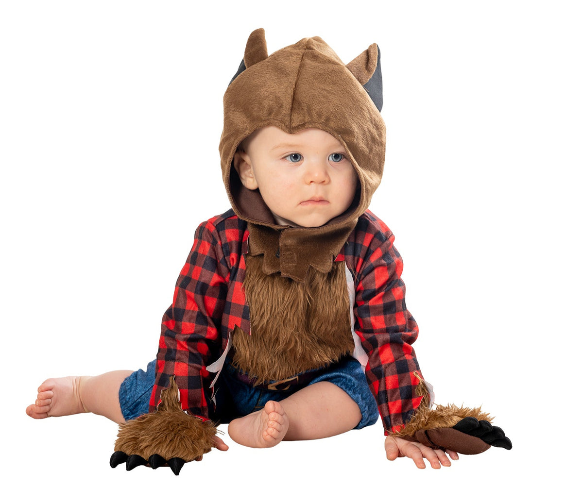 A toddler wearing a werewolf costume with a jumpsuit and headpiece, featuring large ears on the headpiece, sitting on the floor.