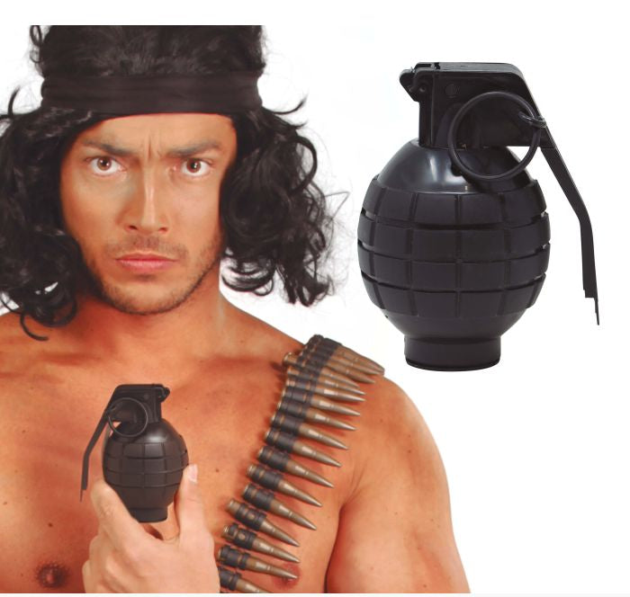 A man wearing a black military-style headband and black costume wig, holding a black toy grenade prop, with a second grenade shown separately on a white background. A bandolier of bullets is also visible across his chest.