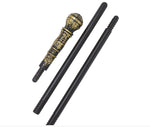 A black metal ceremonial staff or cane with an ornate gold and black carved handle, shown alongside two matching black rods on a white background.