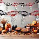 Halloween-themed table setting with pumpkins, skeletons, and decorations.