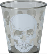 A clear drinking glass featuring a large white skull design on the front, surrounded by smaller matching skull motifs in the background. The glass is photographed against a plain white background, with a copyright notice for Fiestas Guirca s.