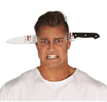 A man wearing a white t-shirt grimaces in pain with a fake bloody knife stuck in both of his ears, set against a plain white background.