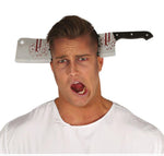 A man wearing a white t-shirt with a novelty costume prop of a cleaver with fake blood dripping onto his head, set against a plain white background.