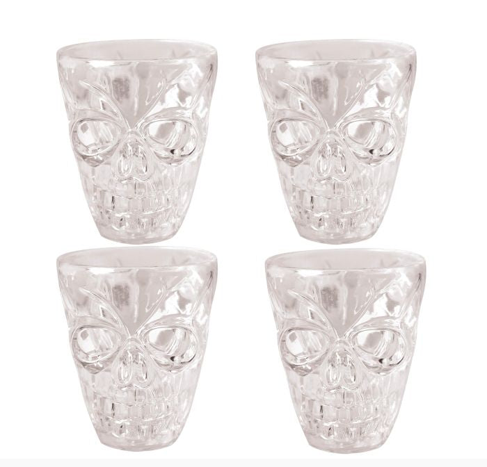Four clear skull-shaped drinking glasses arranged in a 2x2 grid on a white background, with a copyright notice for Fiestas Guirca s.j.