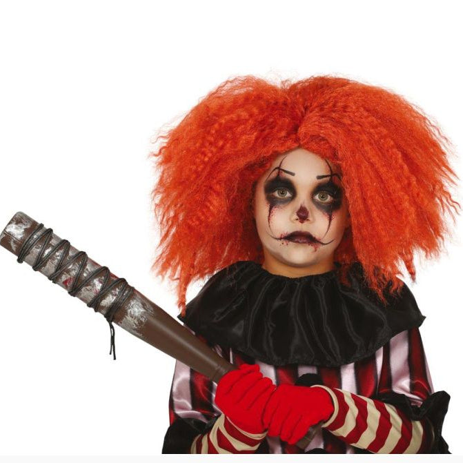 A child dressed as a horror clown with bright orange-red curly hair, black-and-white face makeup, a black ruffled collar, a red-and-white striped shirt, red gloves, and holding a toy baseball bat, photographed on a white background.