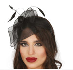 A woman wearing a black fascinator headpiece with sheer mesh, feathers, and a black rose, shown against a plain white background. 