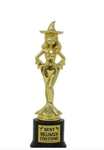 A gold-colored trophy statue of a female witch wearing a pointed hat, mounted on a black cylindrical base with a gold sign that reads 'BEST HALLOWEEN COSTUME'.