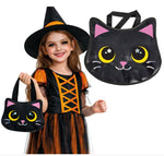 A young girl in a witch costume holds a black cat-shaped Halloween bag with pink ears and yellow eyes, while a larger matching bag is shown beside her on a white background. The product appears to be the cat-shaped handbag/costume accessory rather than the child herself.