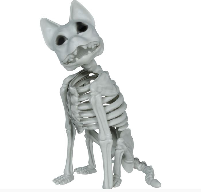 A small gray plastic skeleton dog figurine sitting down, shown against a plain white background with a copyright watermark at the bottom.