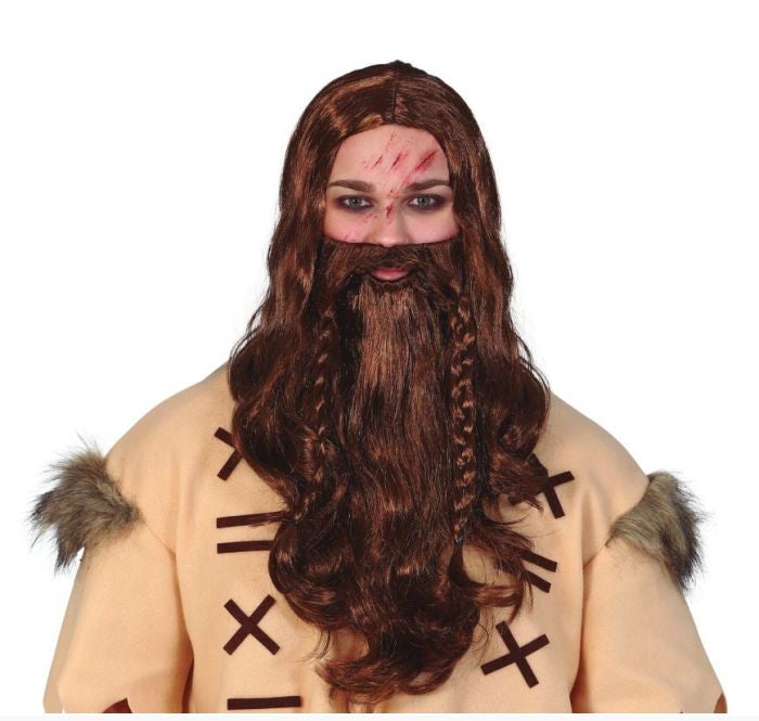 A model wearing a Viking costume wig with long brown hair, a matching beard, and a tan tunic with faux fur trim, against a plain white background.