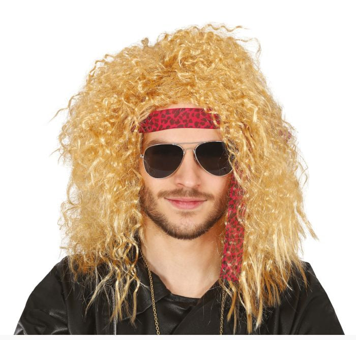 A man wearing a long, curly blonde wig, dark aviator sunglasses, a red patterned headband, and a black shirt against a plain white background.