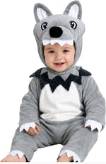 A baby wearing a plush gray and white wolf costume with a hood featuring dog ears, black nose, and white teeth, photographed against a plain white background.