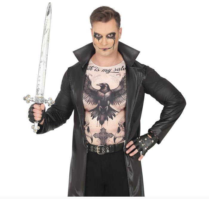 A man modeling a gothic vampire costume consisting of a black faux-leather trench coat, a black raven graphic print shirt, black fingerless gloves, and a black belt, while holding a silver toy sword against a white background.