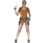A woman modeling a brown short-sleeve jumpsuit costume with black harness straps, a black utility belt, black fingerless gloves, and black thigh straps, holding a silver toy gun against a plain white background.