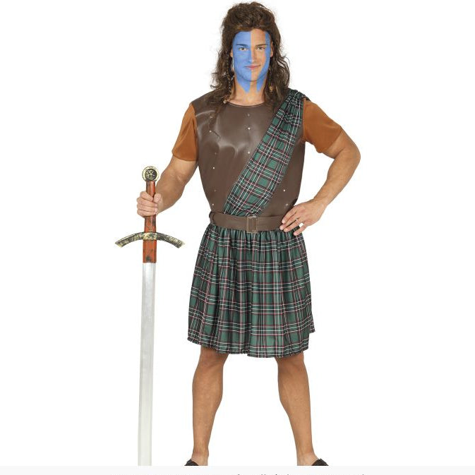 A man modeling a Scottish kilt costume against a white background, holding a toy sword. The costume features a brown faux-leather tunic with tan sleeves, a brown sash, and a green and red tartan kilt.