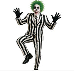 A person modeling a costume with a black-and-white vertically striped suit, black gloves, black shoes, green hair, and white face makeup with black eye makeup, posed against a plain white background.